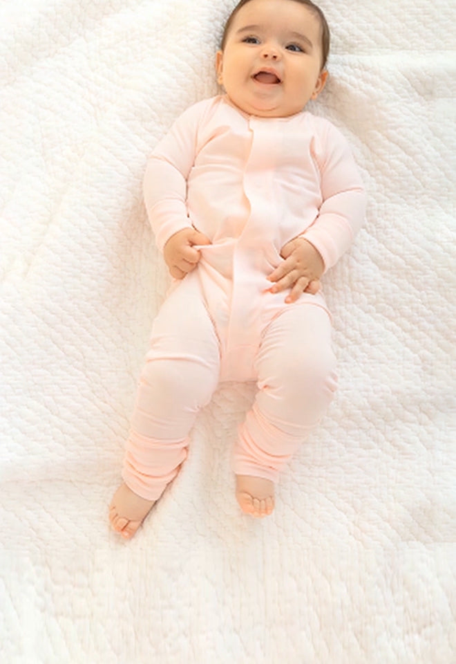 Baby wearing a Convertible Coverall. Button leads to the  Convertible Coverall collection page.