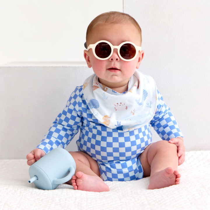 Baby wearing a bodysuit made from CloudStretch™ with the blue and white checker print.