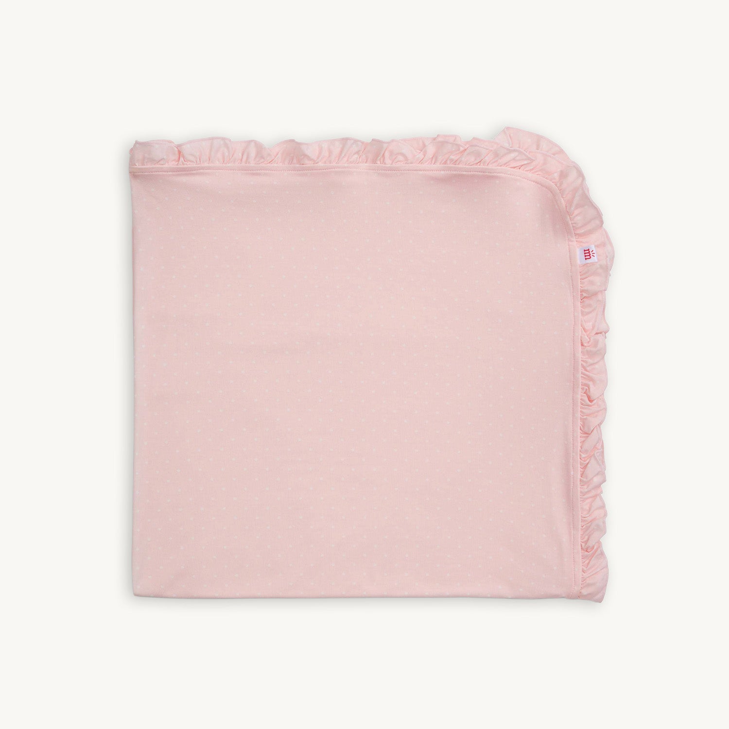 A square 30" x 30" modal receiving blanket in light pink with white pin dots and a wide ruffled fabric border by Magnetic Me.