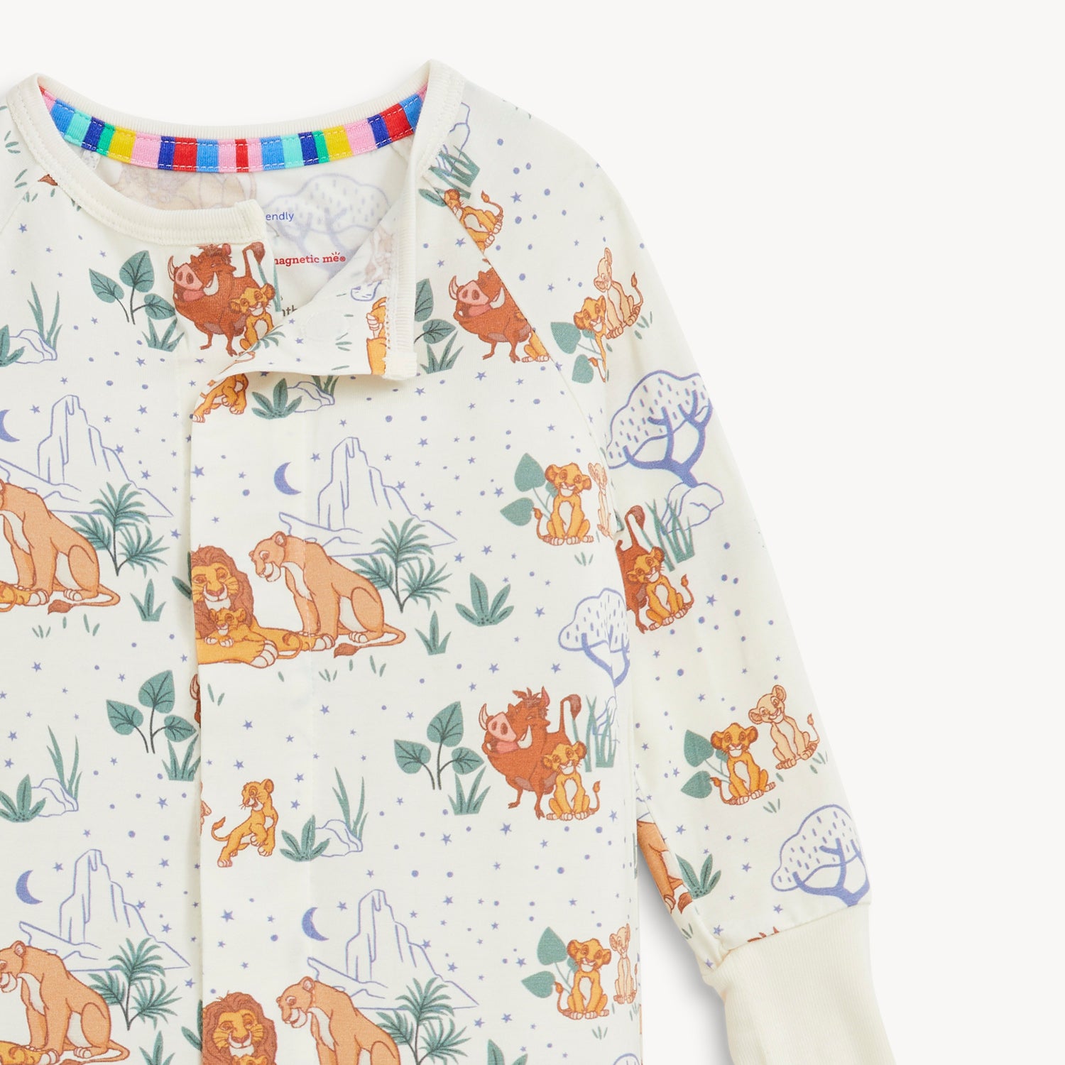 Open magnet in the front center of A cream-colored long-sleeve coverall featuring a repeating pattern of Disney Pumbaa, Simba, and Nala among savanna trees and blue stars by Magnetic Me.
