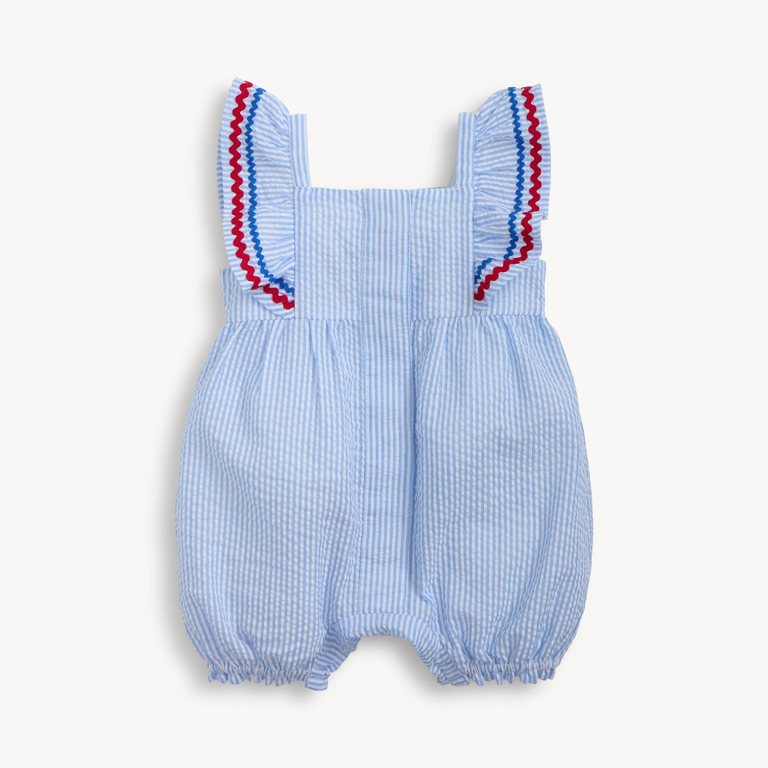 Front of A light blue striped seersucker bubble romper featuring ruffled shoulder straps accented with red and blue rickrack trim, by Magnetic Me.