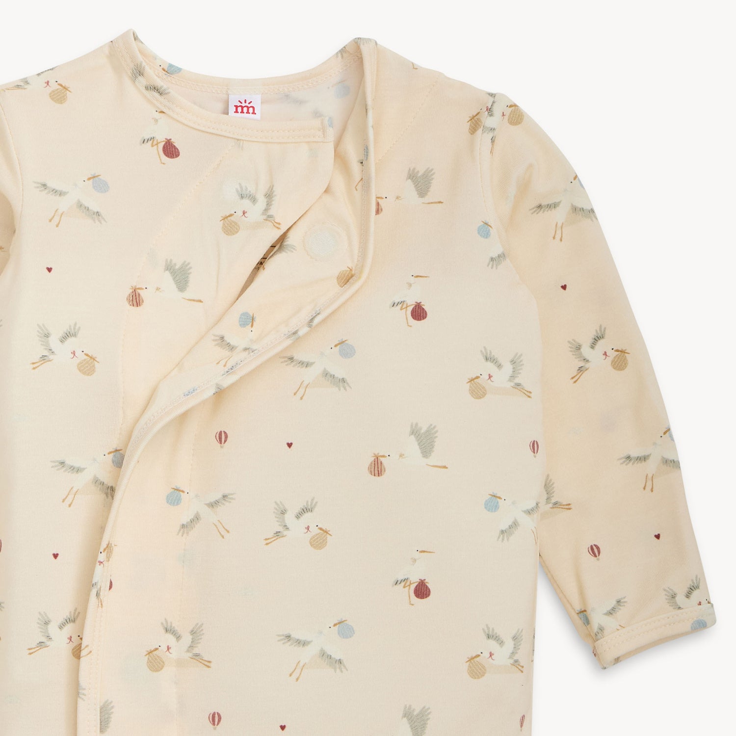 Open magnet of A gown and matching beanie set in a cream stork-themed print with a side-fastening magnetic closure, by Magnetic Me.