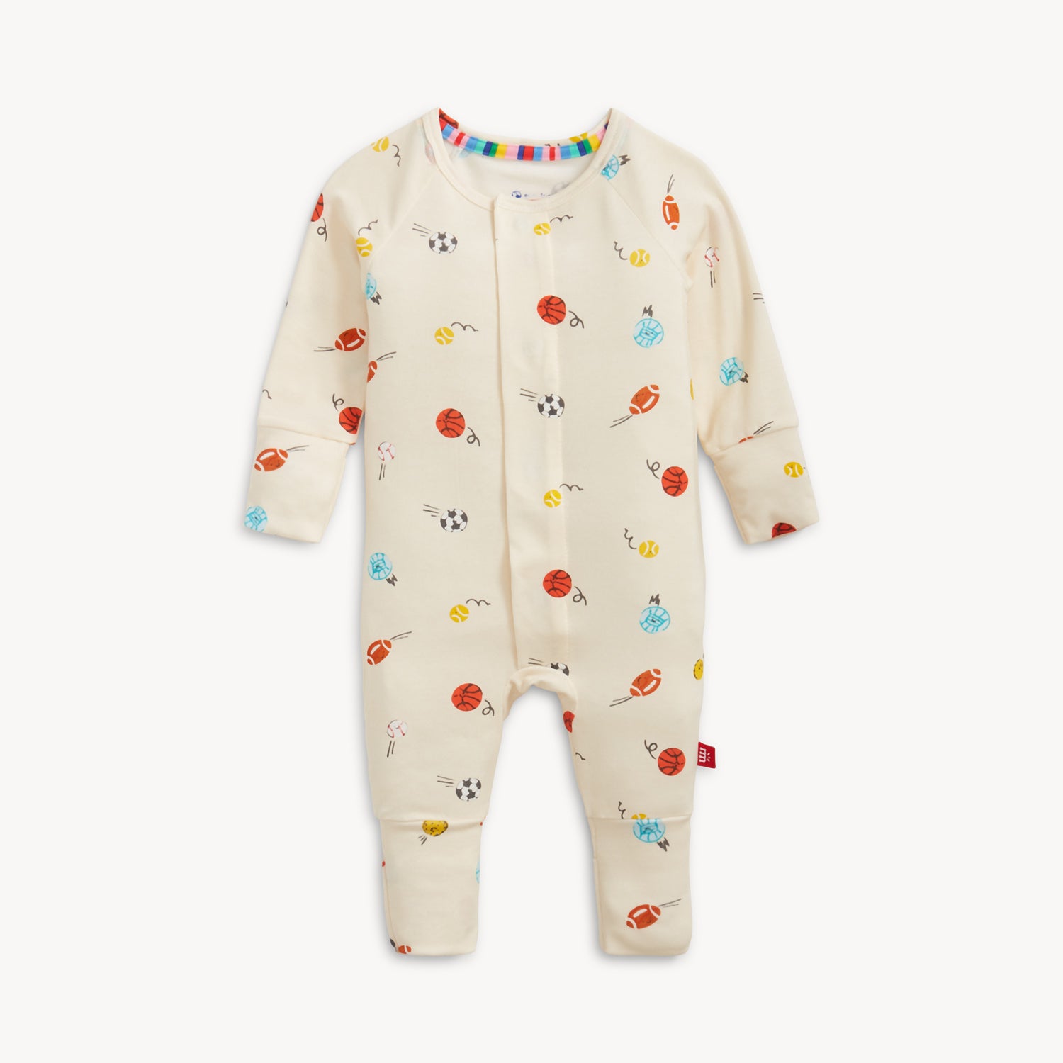 A cream-colored long-sleeve convertible coverall with cuffed ankles and a repeating pattern of animated footballs, basketballs, and soccer balls, by Magnetic Me.