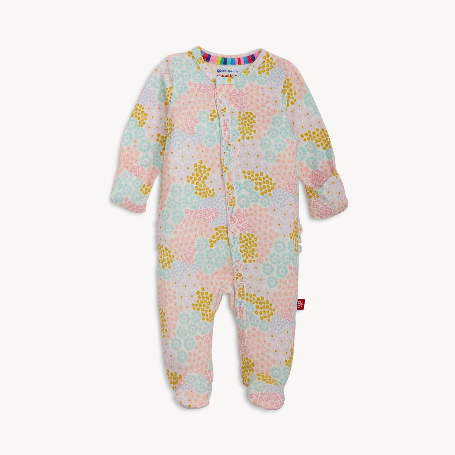 A long-sleeve footie with a vertical ruffle along the zipper featuring a dense print of pink, purple, and blue wildflowers on white fabric, by Magnetic Me.