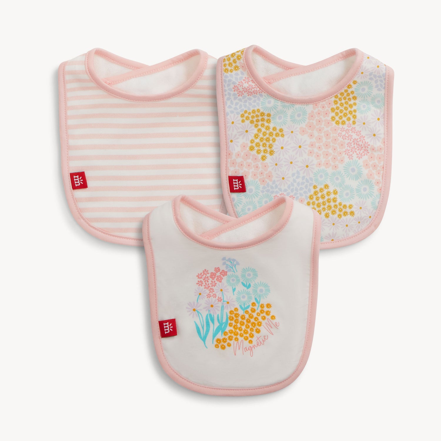 A three-pack of infant bibs featuring a pink and white striped pattern, an all-over dense pastel floral print, and a single floral bouquet graphic on a white background, by Magnetic Me.