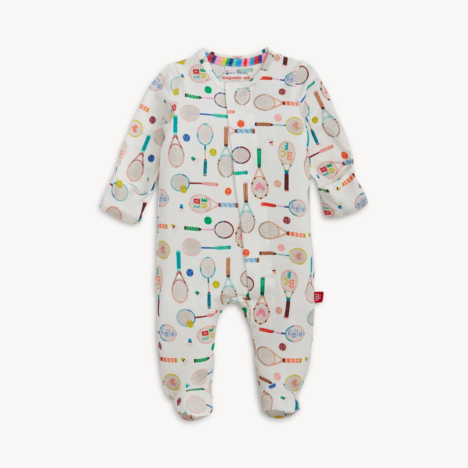 A long-sleeve cream footie featuring a playful, multi-colored pattern of tennis rackets, balls, and badminton shuttlecocks, by Magnetic Me.