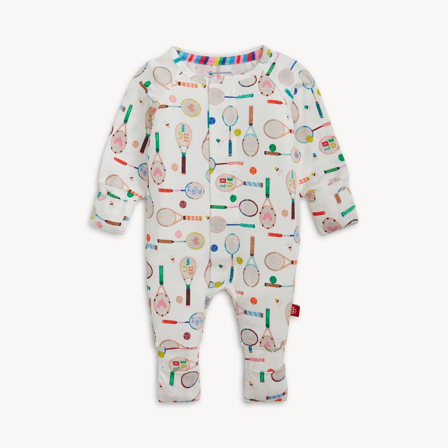 A cream-colored long-sleeve convertible coverall with a colorful repeating print of sports rackets and tennis balls, by Magnetic Me.