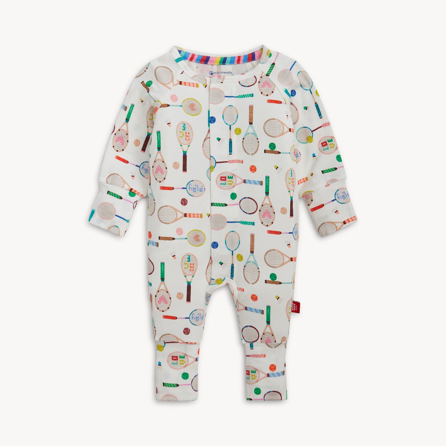 A cream-colored long-sleeve convertible coverall with a colorful repeating print of sports rackets and tennis balls, by Magnetic Me.