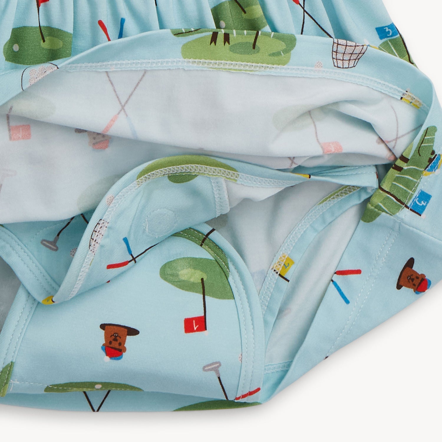A view of the underside of the baby bodysuit dress showing the integrated diaper cover with magnetic closures for quick changes by Magnetic Me.