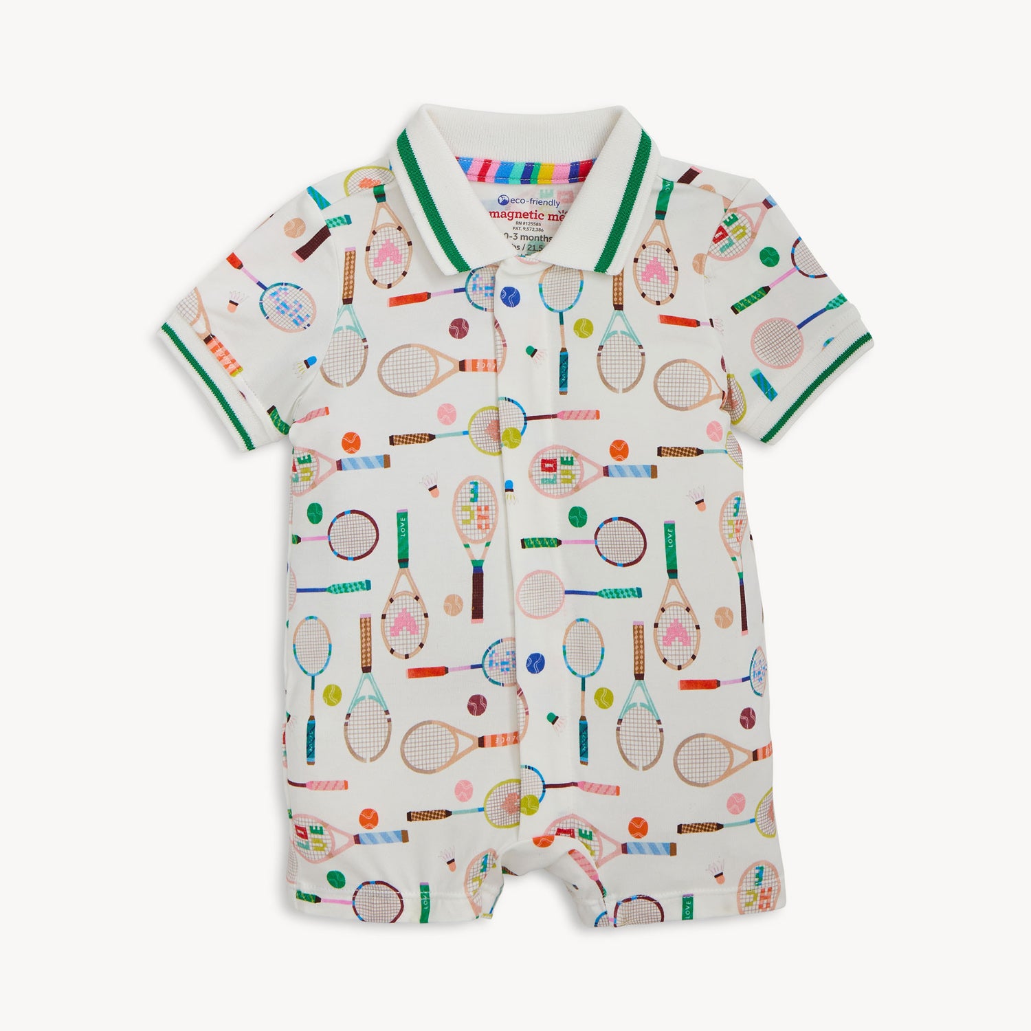 A cream-colored short-sleeve romper with a green-trimmed polo collar, featuring a repeating print of tennis rackets, shuttlecocks, and colorful sports balls, by Magnetic Me.