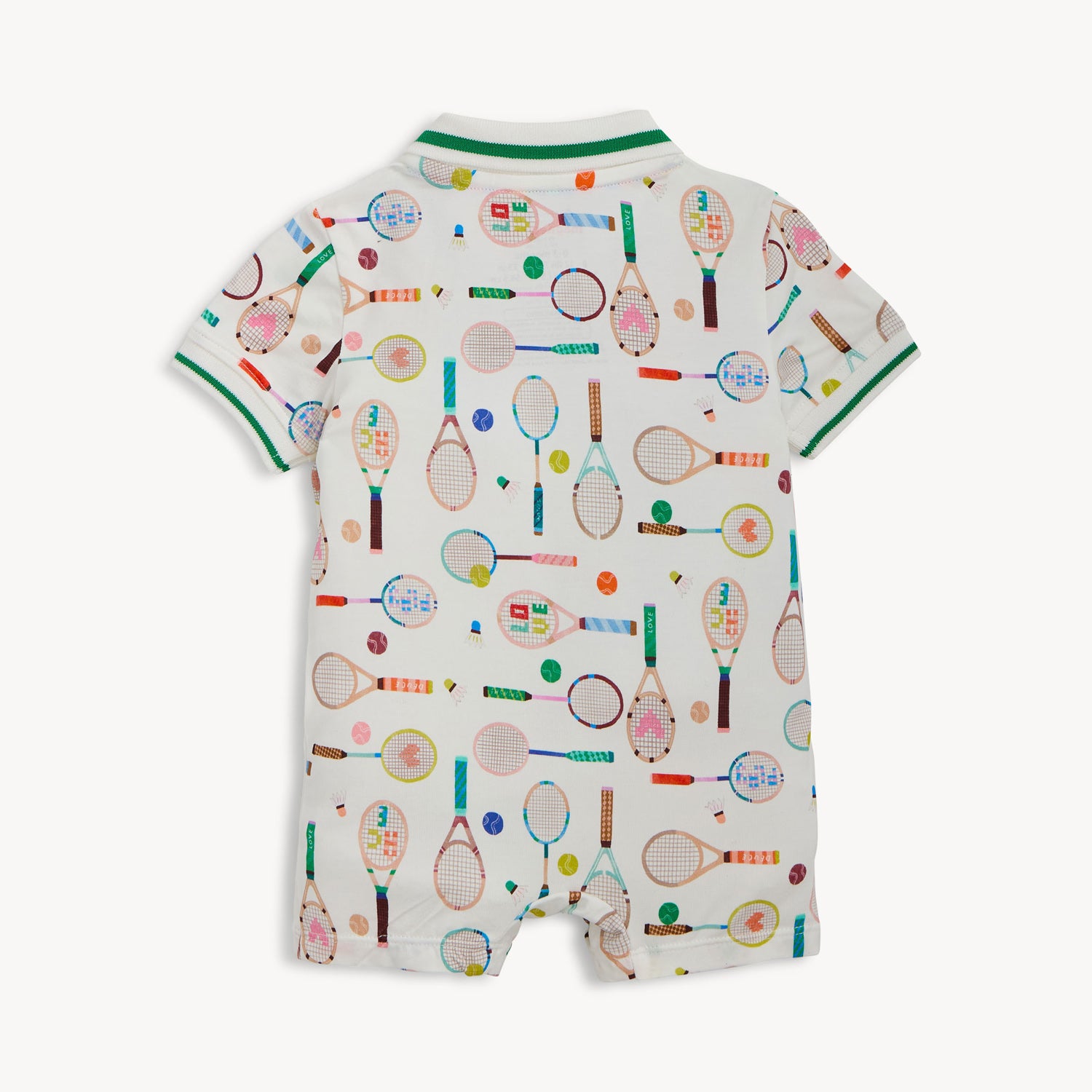 Back of A cream-colored short-sleeve romper with a green-trimmed polo collar, featuring a repeating print of tennis rackets, shuttlecocks, and colorful sports balls, by Magnetic Me.