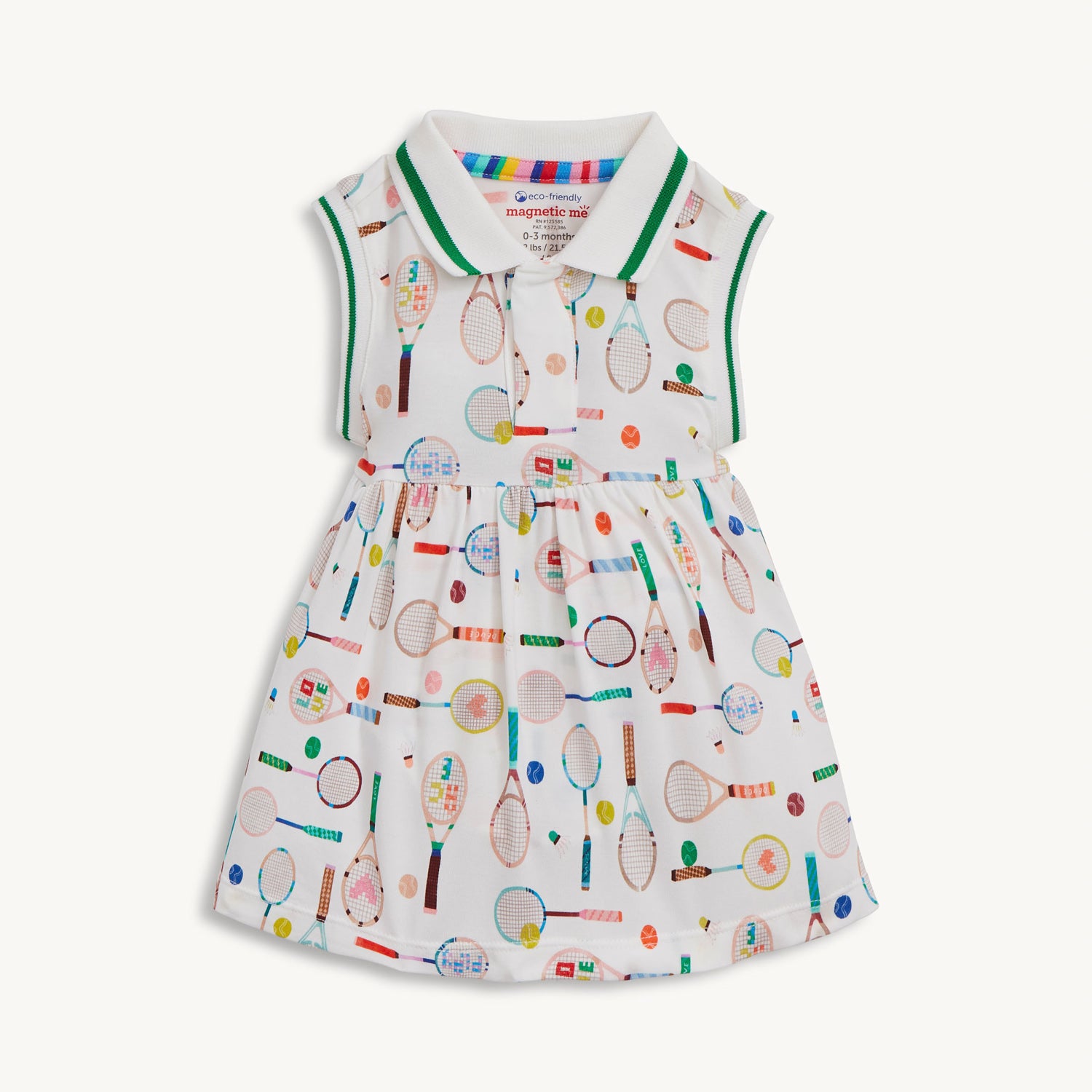 A sleeveless cream-colored dress with a pink-trimmed polo collar and an integrated bodysuit, featuring a colorful print of tennis rackets, balls, and shuttlecocks, by Magnetic Me.