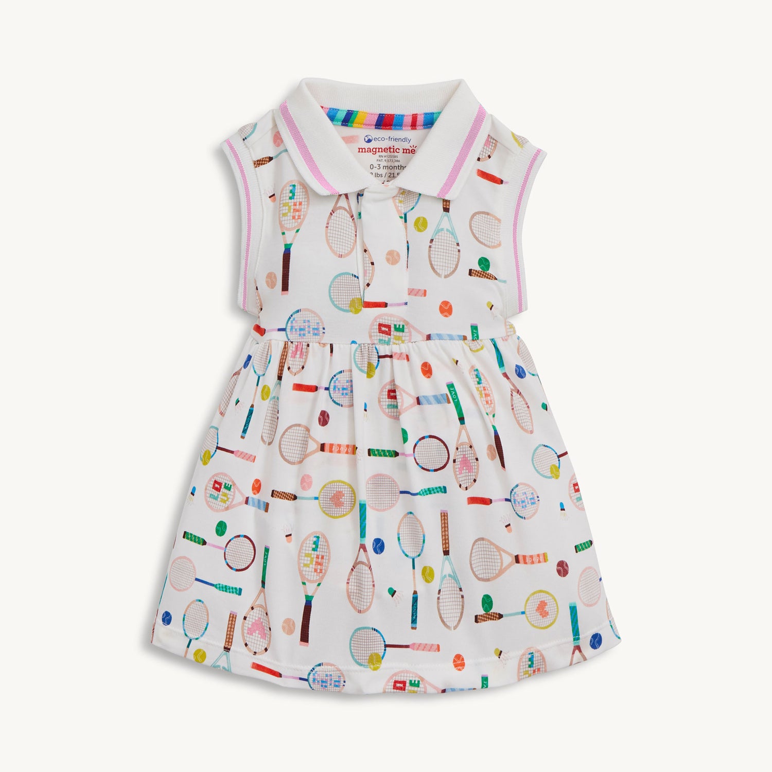 A sleeveless cream-colored dress with a pink-trimmed polo collar and an integrated bodysuit, featuring a colorful print of tennis rackets, balls, and shuttlecocks, by Magnetic Me.
