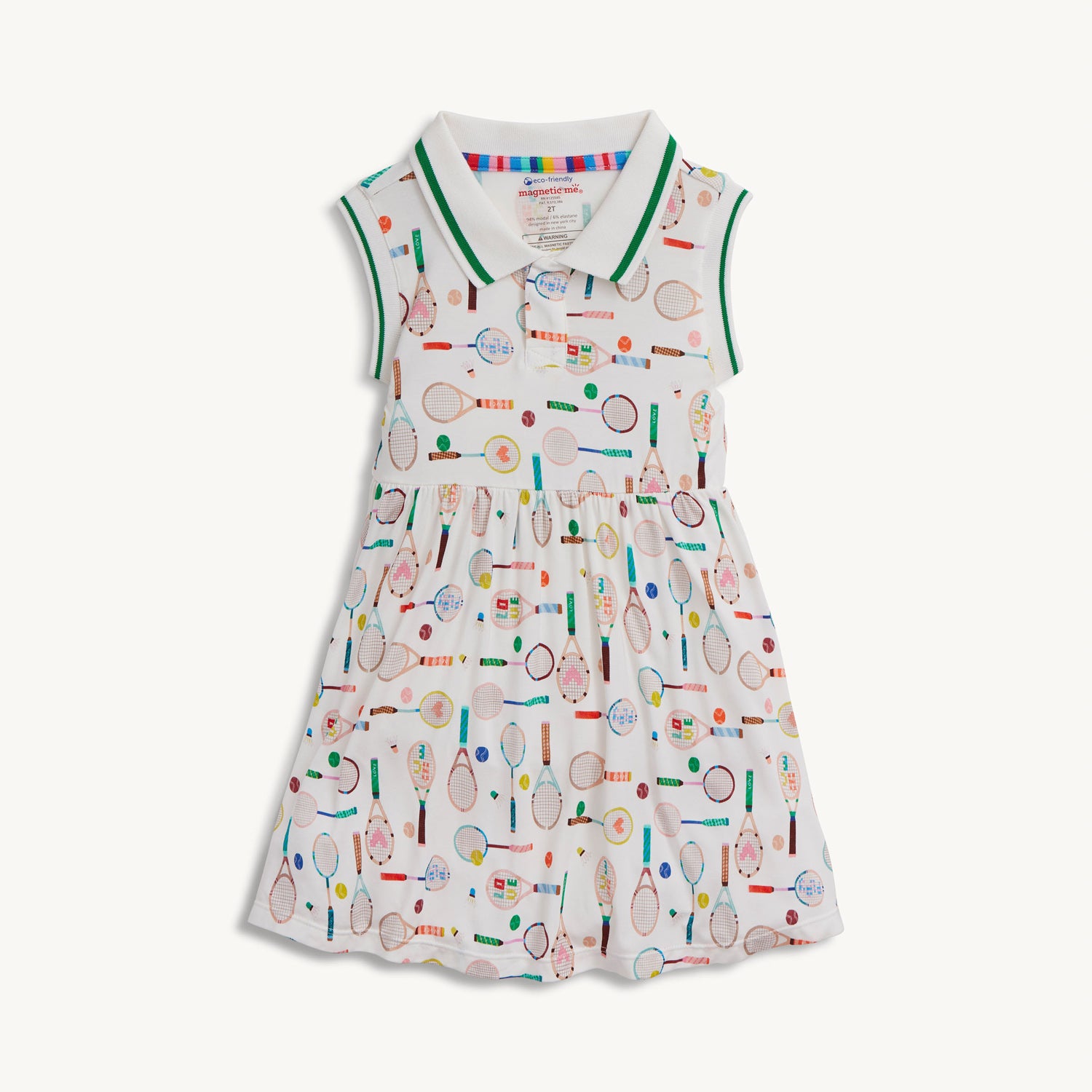 A cream sleeveless polo dress with a grey and white striped collar, decorated with a whimsical pattern of multi-colored tennis and badminton equipment, by Magnetic Me.