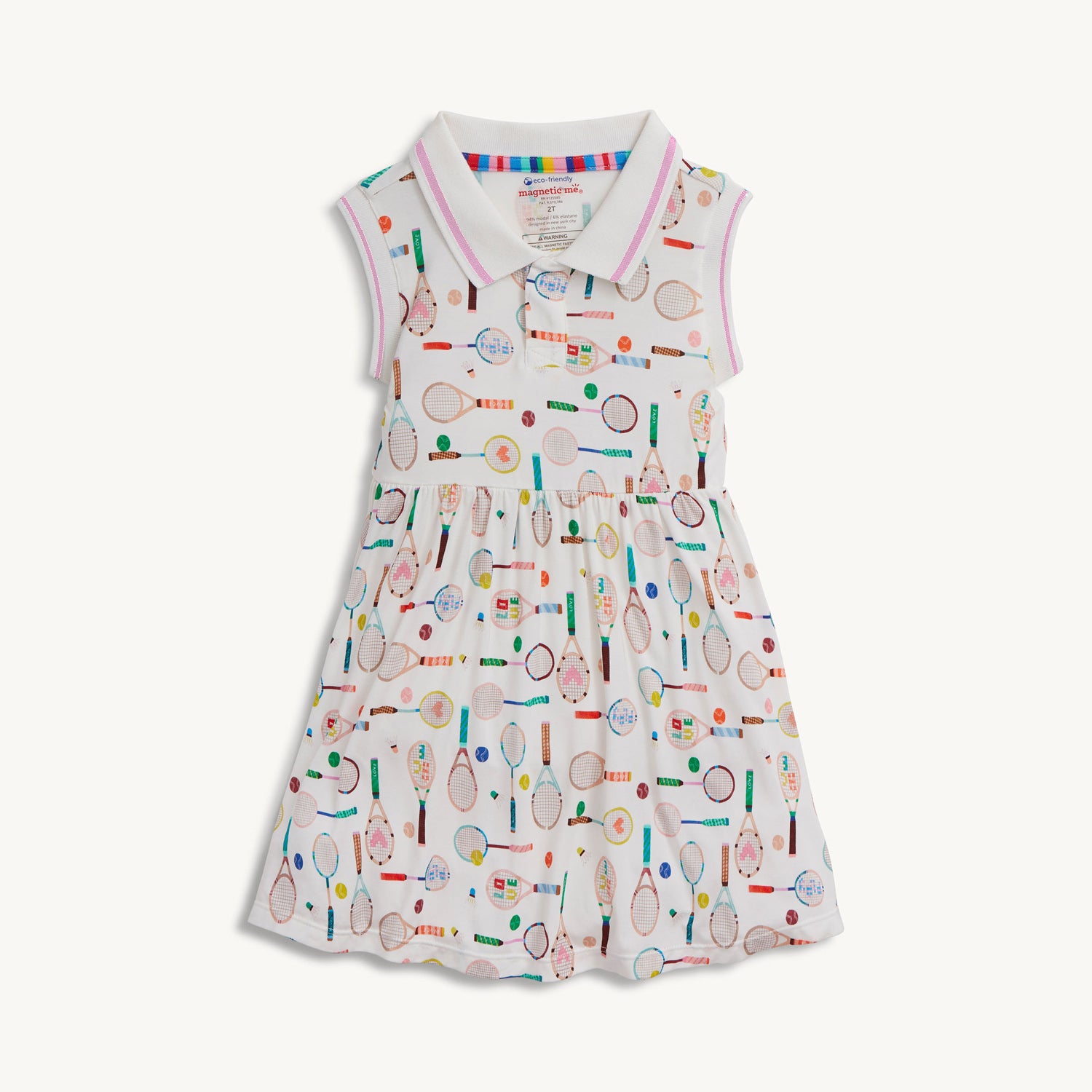 A cream sleeveless polo dress with a pink and white striped collar, decorated with a whimsical pattern of multi-colored tennis and badminton equipment, by Magnetic Me.