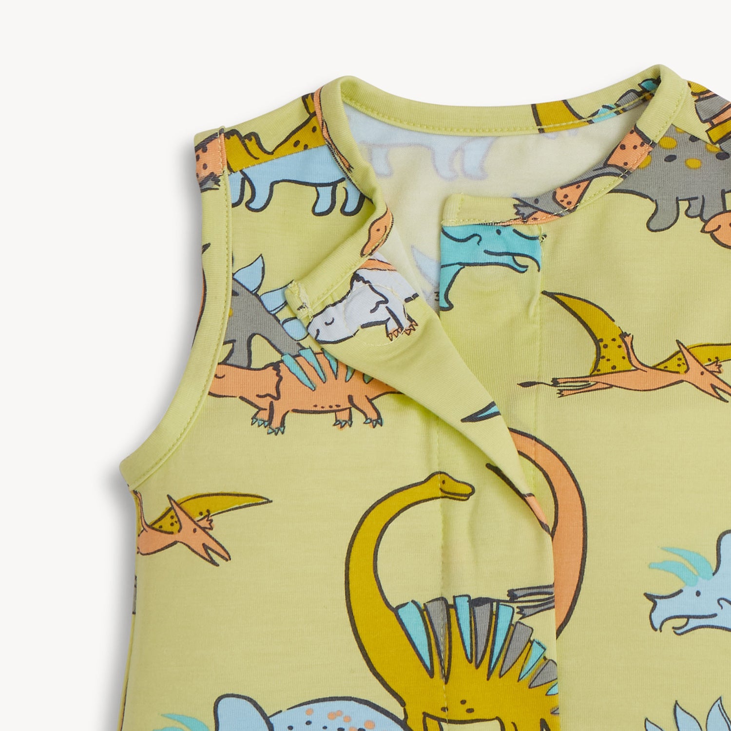 Open magnet in the center front of A sleeveless one-piece romper in lime green with a vibrant all-over print of prehistoric dinosaurs and flying pterodactyls, by Magnetic Me.