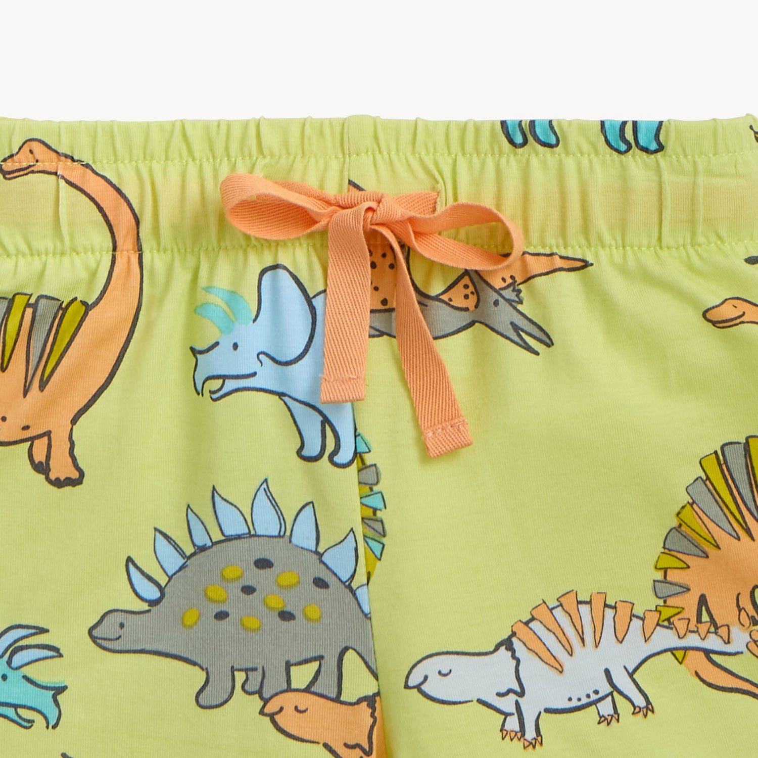 Children's shorts with dinosaur pattern and orange drawstring, by Magnetic Me.
