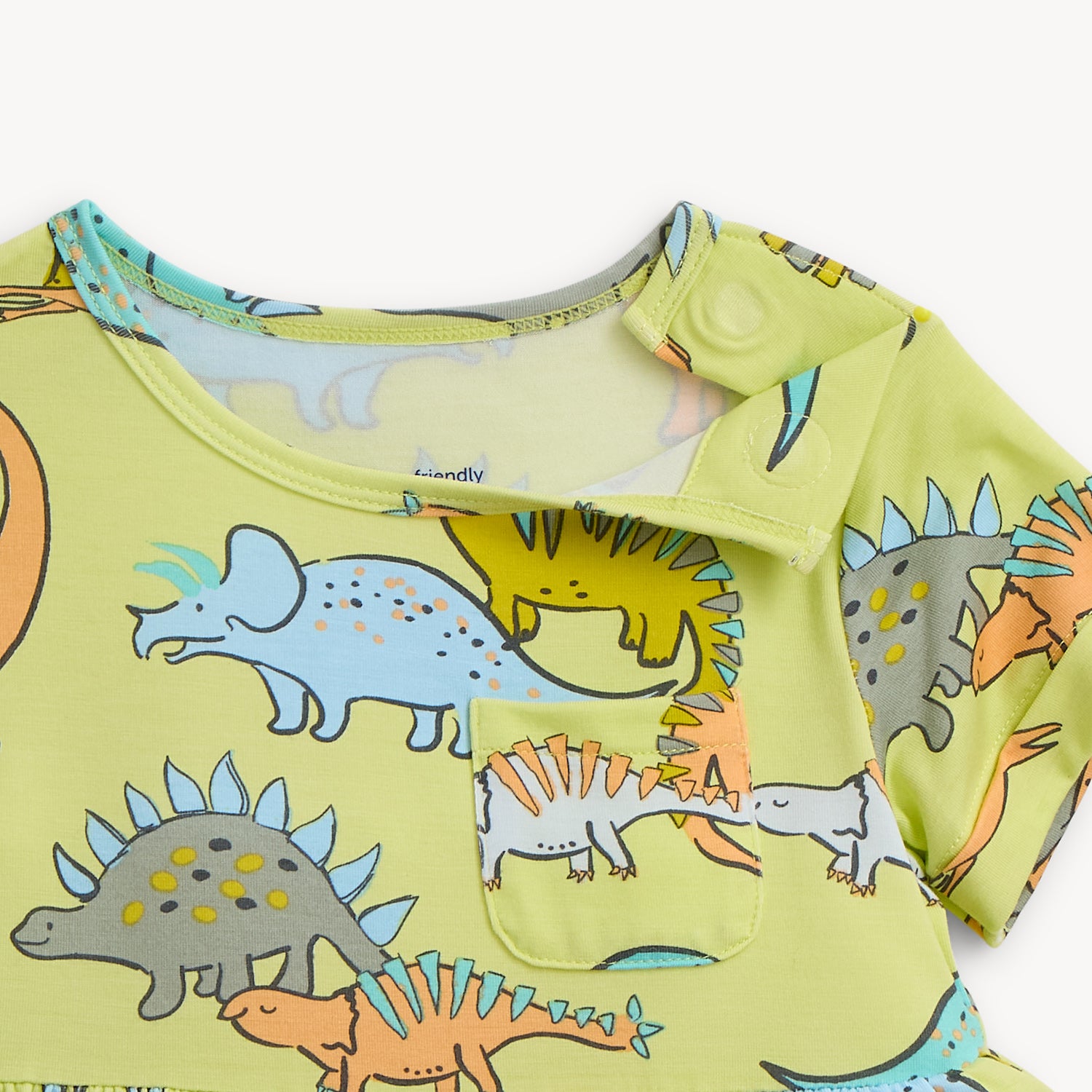 Open magnet on the shoulder area of A lime green A-line dress for girls featuring a chest pocket and a playful print of diverse, multi-colored dinosaurs, by Magnetic Me.