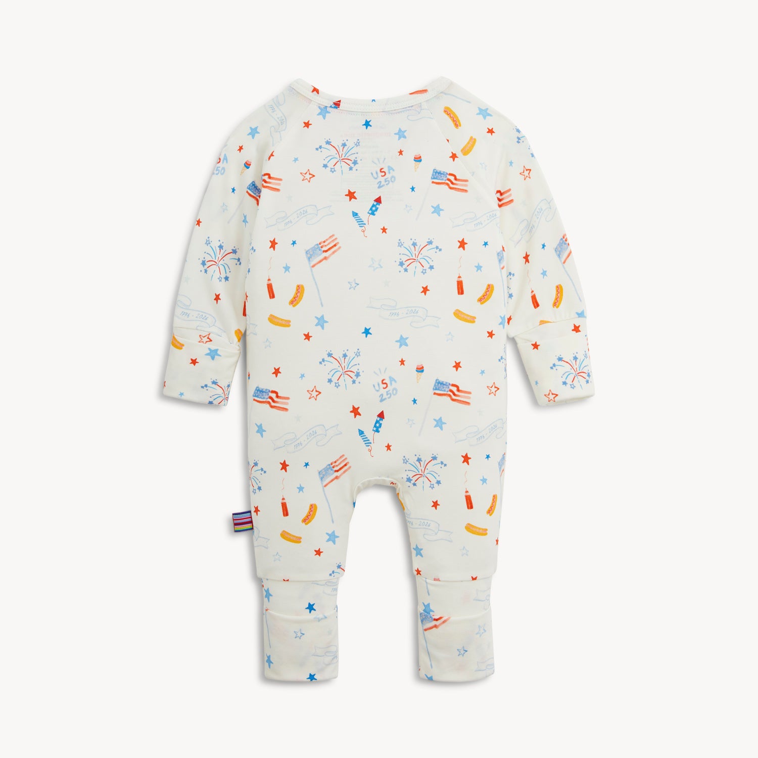 Back of the white long-sleeve convertible coverall decorated with a festive repeating print of stars, banners, and picnic foods, by Magnetic Me.