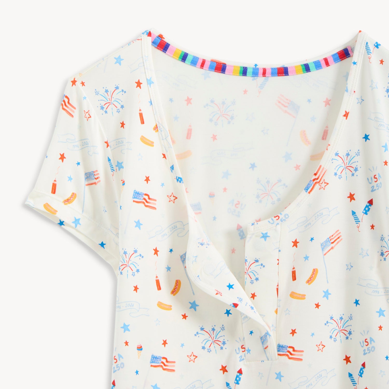 Open magnet in the center front of A women's two-piece set featuring a V-neck short-sleeve top and long pants in white fabric with an all-over patriotic holiday print, by Magnetic Me.