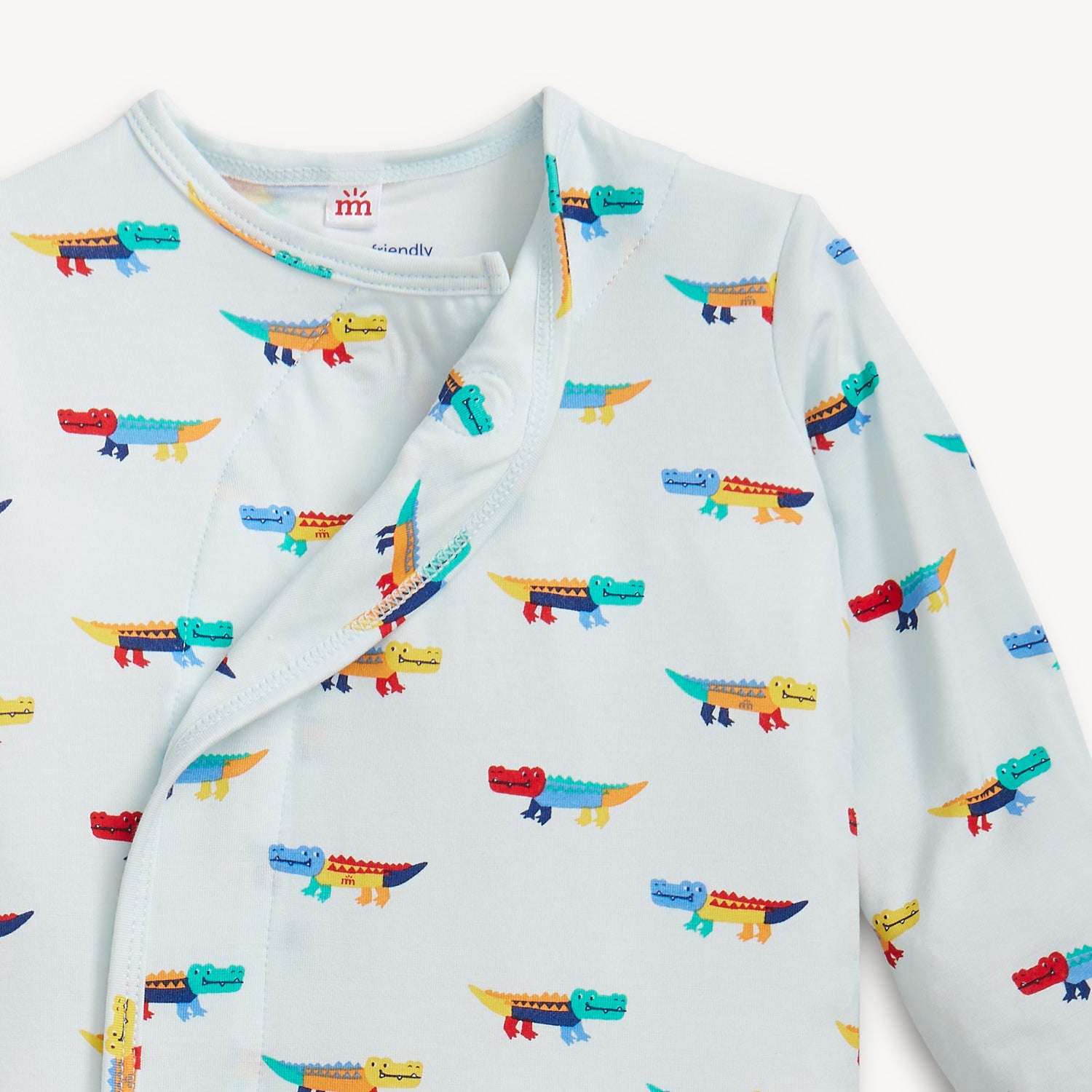 Open magnet in the center of A cozy sleeper gown and matching knotted hat set in light blue with an all-over print of colorful, stylized crocodiles, by Magnetic Me.