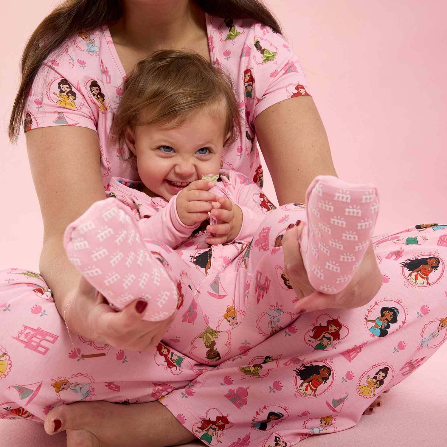 Woman and child wearing matching Princess Royal pink pajamas by Magnetic Me.