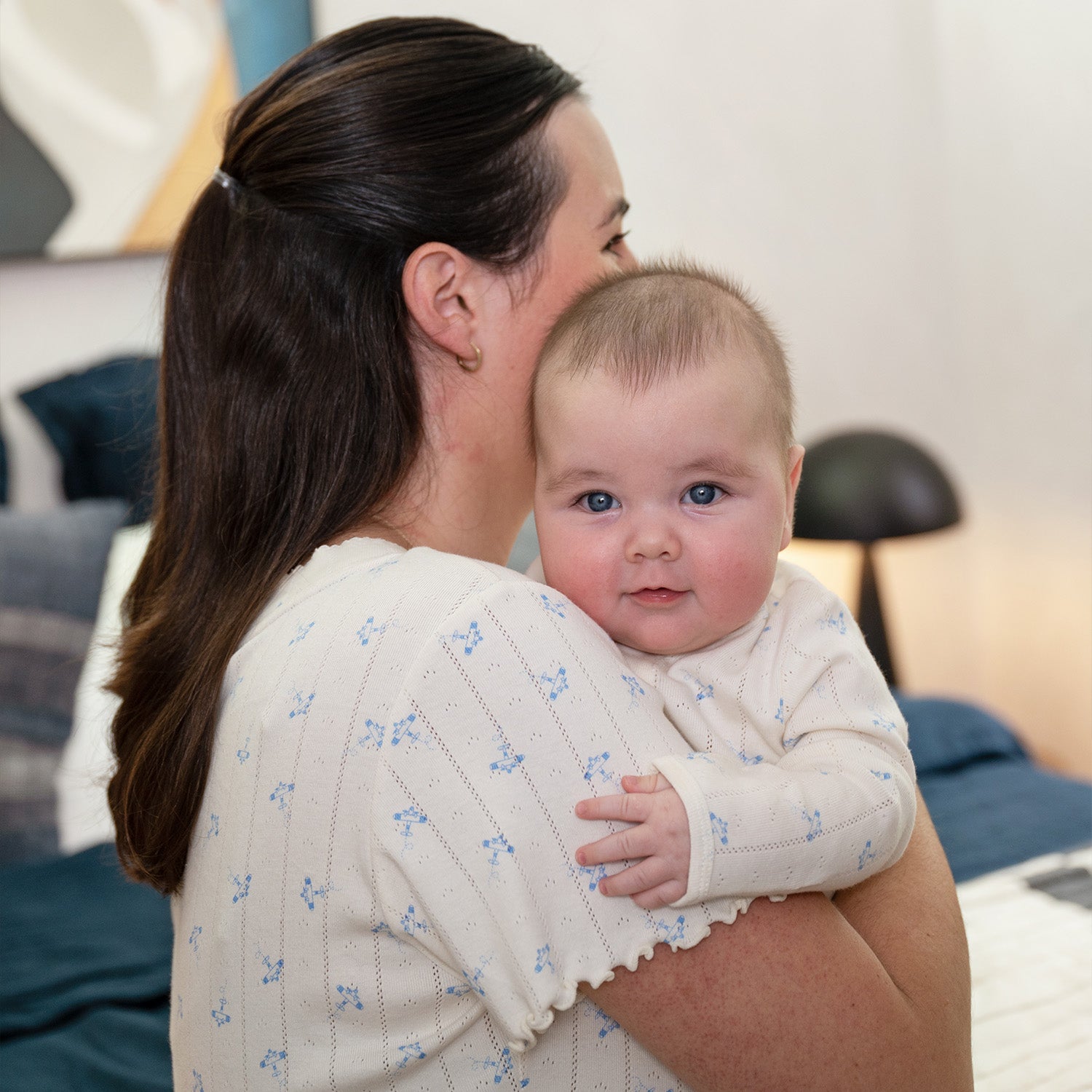 Woman holding a baby in a cozy indoor setting