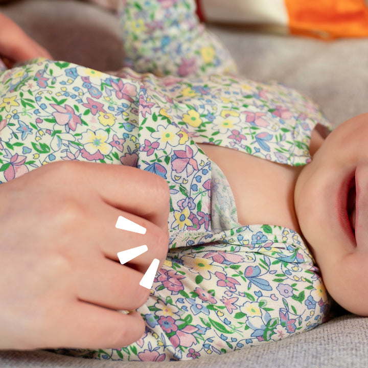 A mother opening a magnet of a floral print footie 